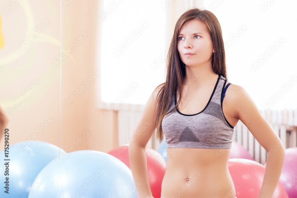 Sport, Fitness, Wellness and Lifestyle Concepts. Caucasian Sexy Female Athlete Posing In Gym Against Big Fitballs On Background in Gym.