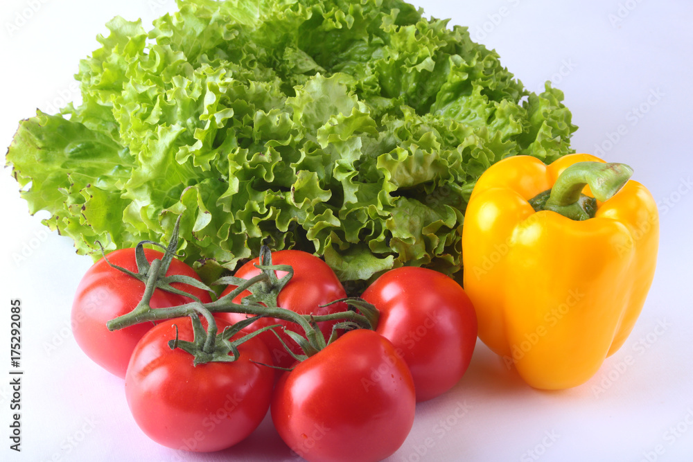Fresh assorted vegetables bell pepper, tomato, garlic with leaf lettuce. Isolated on white background. Selective focus. Fresh assorted vegetables bell pepper, tomato, garlic with leaf lettuce. Isolated on white background. Selective focus.