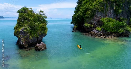 Aerial: A man swims on a kayak near the island in Andaman sea. Thailand.