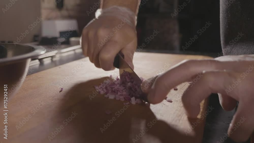 Chef cutting up an onion with a knife Chef cutting up an onion with a knife
