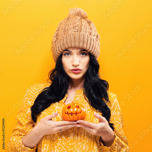 Young woman holding a pumpkin in halloween theme