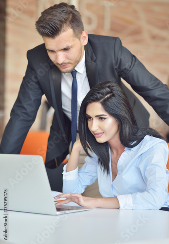 business couple in an office working on the computer photo