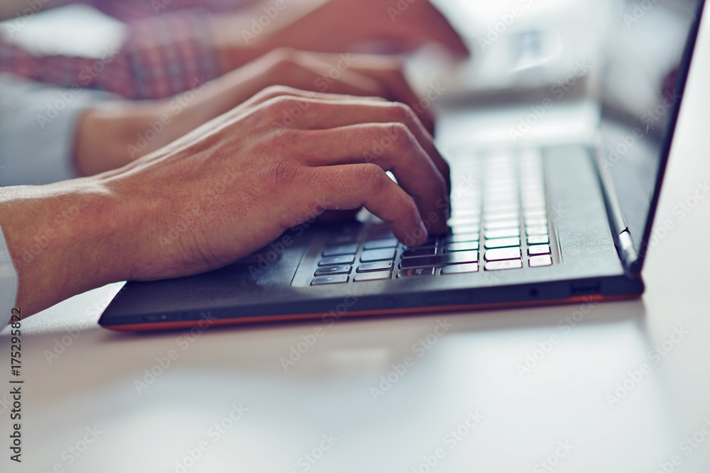 Man's hands typing on laptop keyboard Man's hands typing on laptop keyboard