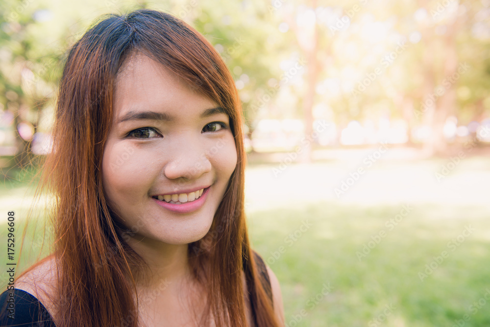 Calm beautiful smiling young woman with ponytail enjoying fresh air outdoor, relaxing with eyes closed, feeling alive, breathing, dreaming. Copy space, green park nature background. Side view portrait Calm beautiful smiling young woman with ponytail enjoying fresh air outdoor, relaxing with eyes closed, feeling alive, breathing, dreaming. Copy space, green park nature background. Side view portrait