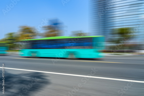 Blurred bus on the road with modern office building