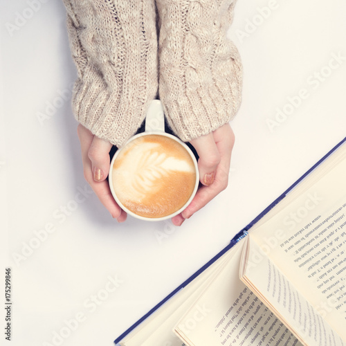 Girl holding cup of coffee with latte art. Leasure time concept. Pastel colors