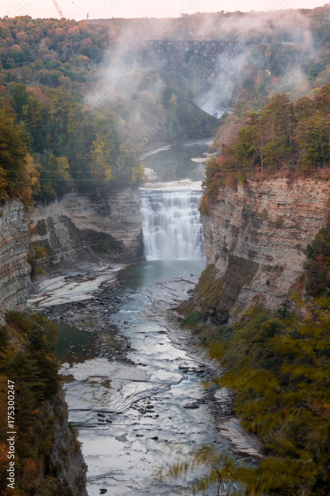 Inspiration Point in early Autumn at dusk is the sight of beautiful Waterfalls and train trestle at Letchworth State Park, NY, portrait