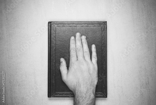 Photography mans hand on the book, the oath on the Bible