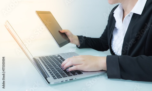 Business woman working on table with notebook and tablet