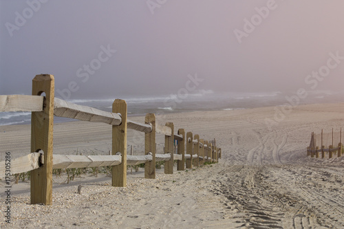 Fototapeta Naklejka Na Ścianę i Meble -  Wooden railing leading to the shore and swimming in epic and conceptual hilltop perspective.  Copy space for words.