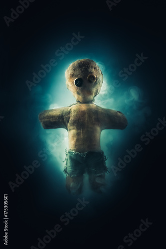 High contrast image of voodoo doll with smoke