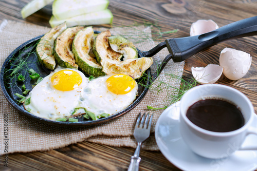 Home-made Breakfast - scrambled eggs, zucchini slices and black coffee.