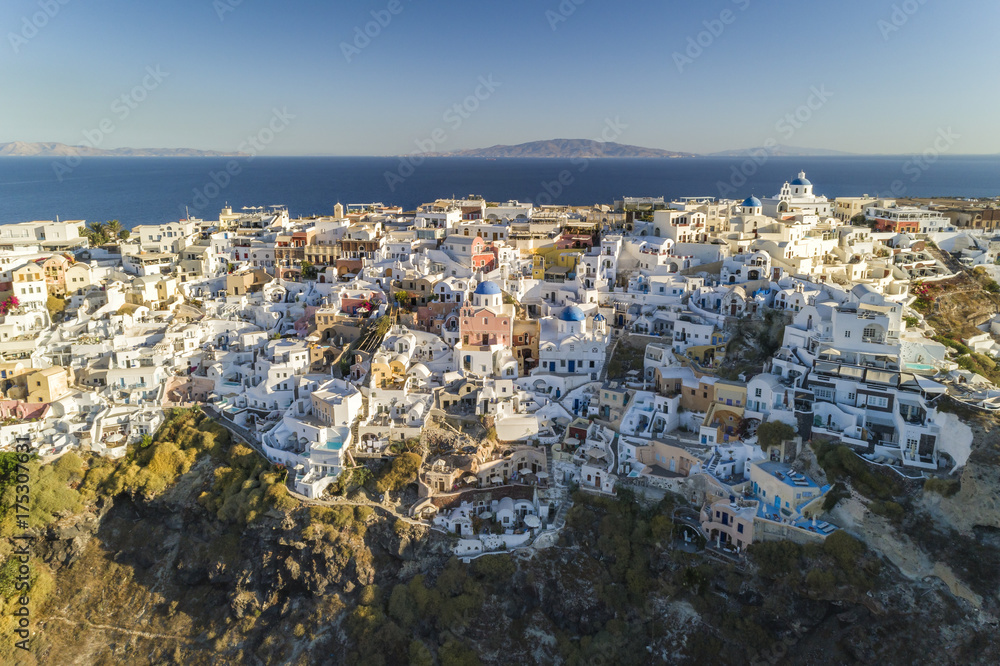 Aerial view of white houses on the steep cliff in Oia, Santorini Island, Greece