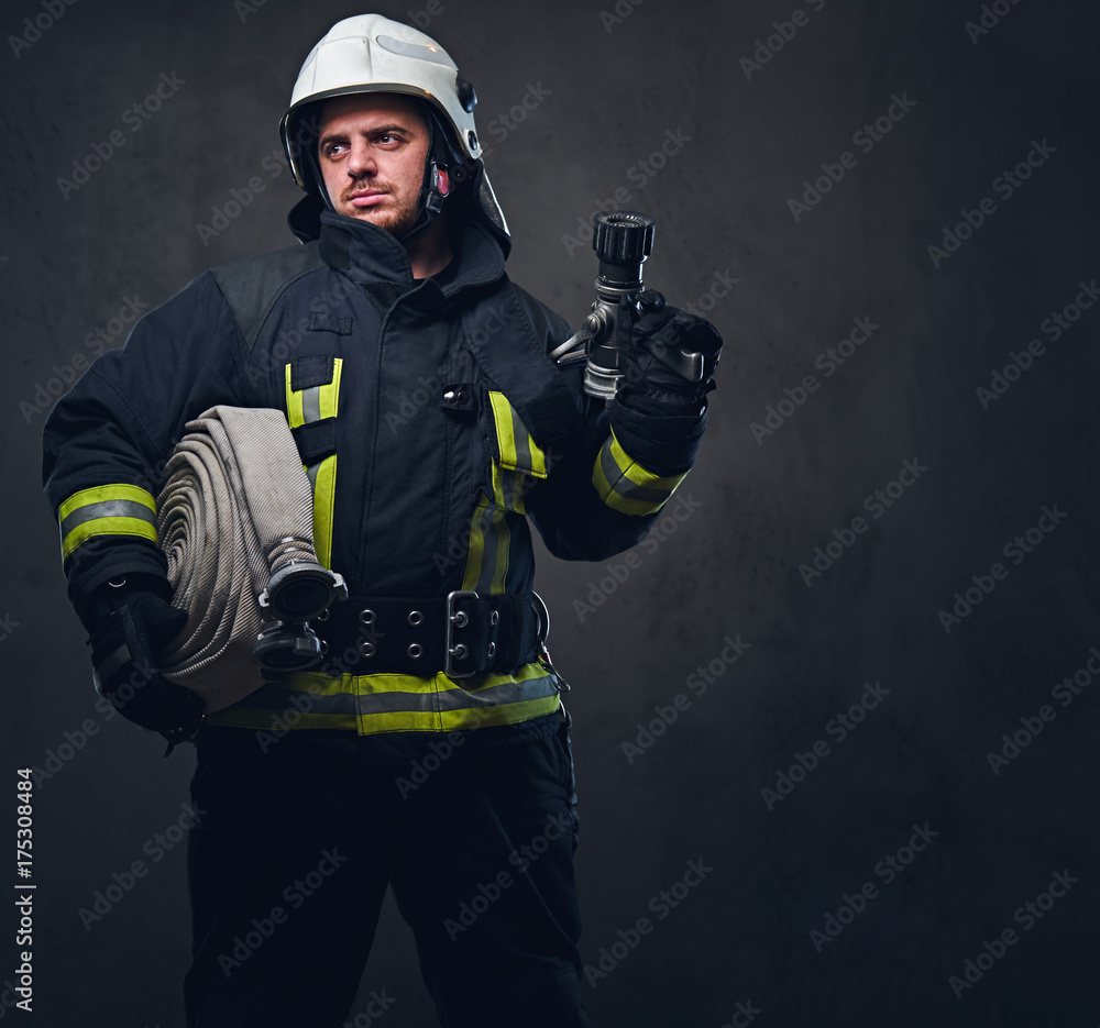 Firefighter in uniform holds fire hose. Firefighter in uniform holds fire hose.