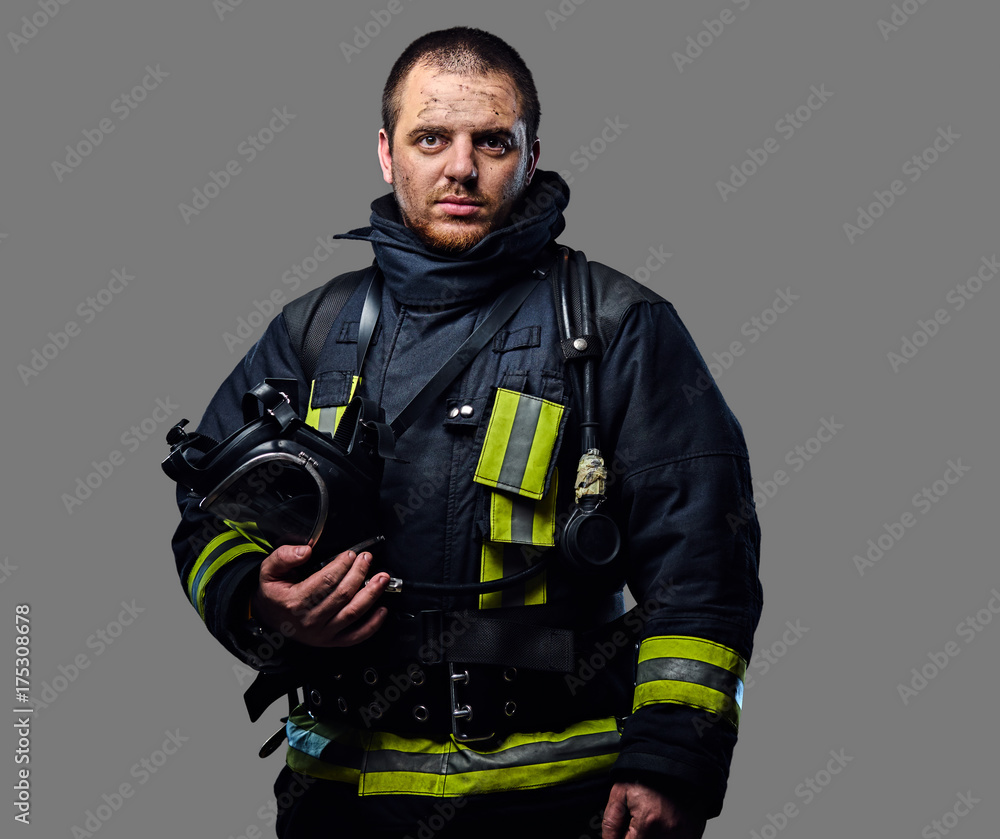 Fototapeta premium Studio portrait of a male dressed in a firefighter uniform.