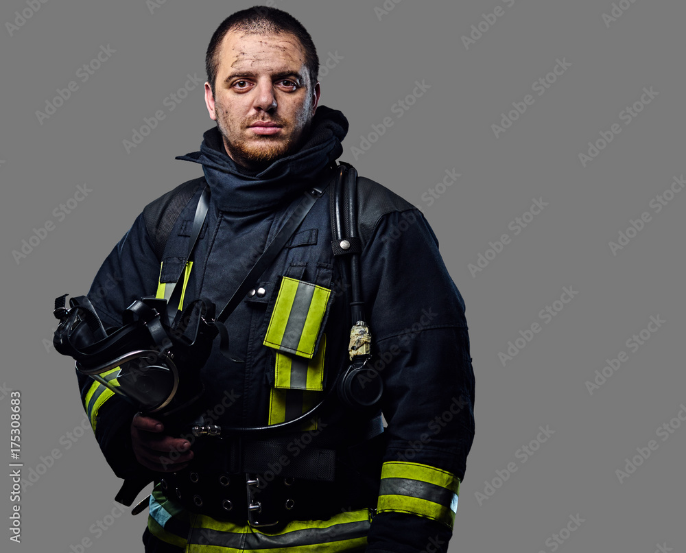 Obraz premium Studio portrait of a male dressed in a firefighter uniform.