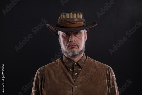 studio portrait of a cowboy, dark background