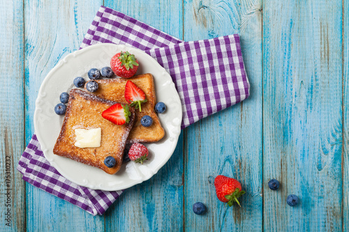 Traditional, delicious, sweet French toast with fruit and butter.