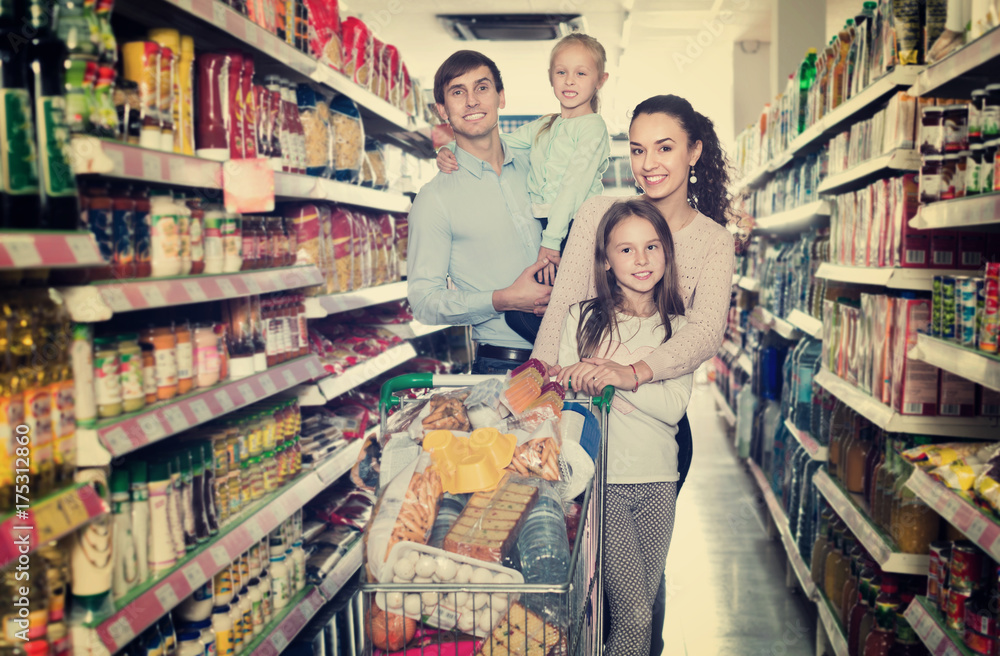 Cheerful  customers with children buying food in hypermarket