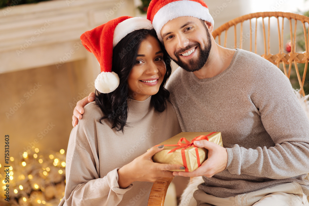 Fototapeta premium Happy international couple posing with Christmas present
