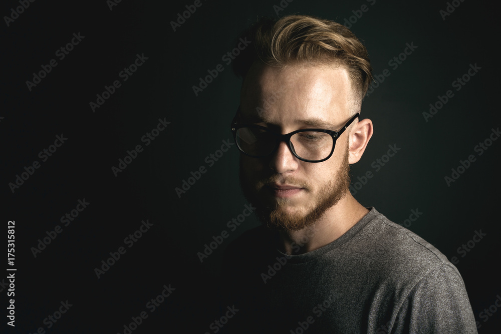 portrait of young man above black background portrait of young man above black background