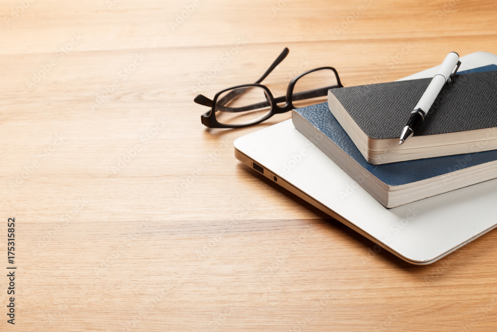 Notepad and laptop on wooden table Notepad and laptop on wooden table