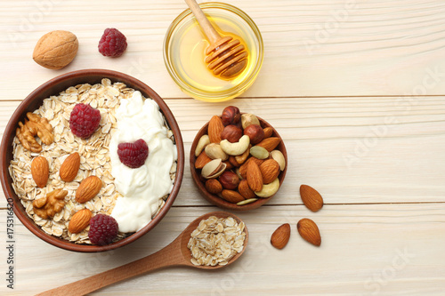 healthy breakfast. oatmeal, honey and nuts on white wooden table. Top view with copy space