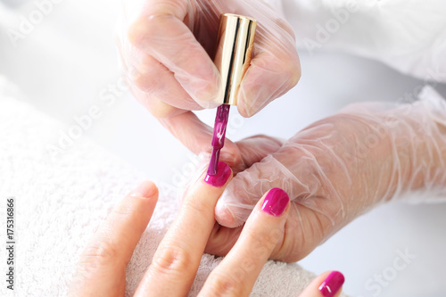 Manicure, piękne zdrowe paznokcie. Zabieg pielęgnacyjny dłoni i paznokci, kobieta u kosmetyczki na zabiegu manicure.