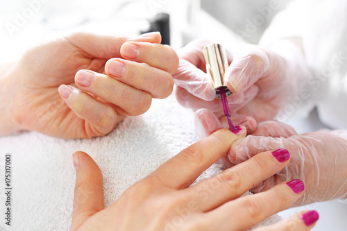Malowanie paznokci, manicure.Zabieg pielęgnacyjny dłoni i paznokci, kobieta u kosmetyczki na zabiegu manicure.