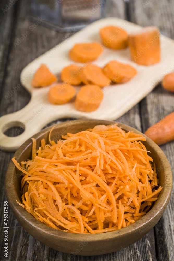 Grate carrots in a bowl Grate carrots in a bowl