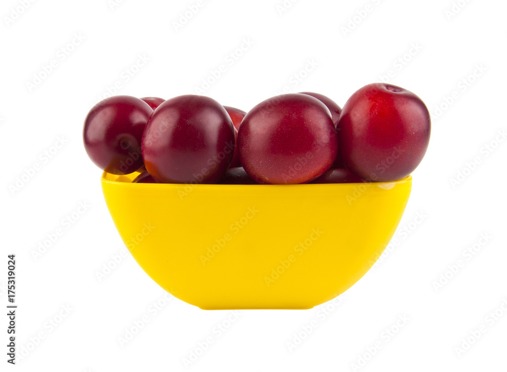 Plum in a yellow plate isolated on a white background Plum in a yellow plate isolated on a white background