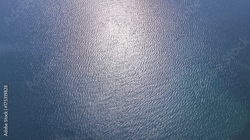 Vista aerea delle acque blu del mar Mediterraneo e nello specifico del mar Tirreno. La luce del sole si riflette sulla superficie dell'acqua.