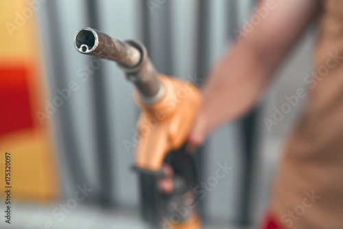 Close up. A man pumping or putting gasoline fuel in a car at gas station. Car refueling