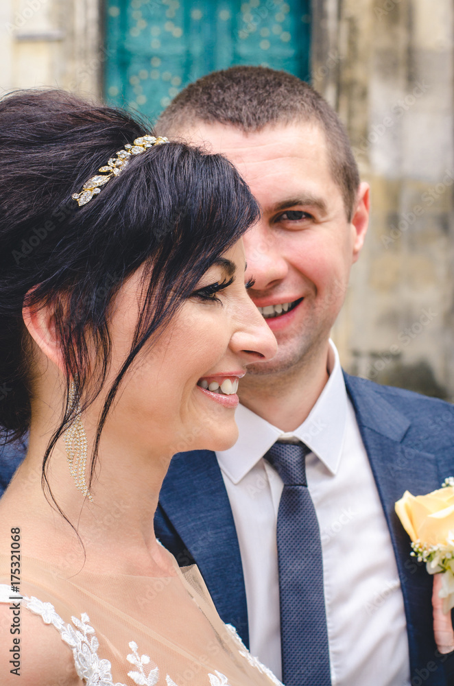 Fashionable close up portrait of the bride and groom against the background of the old castle. Wedding day. Young smiling beautiful couple. Fashionable close up portrait of the bride and groom against the background of the old castle. Wedding day. Young smiling beautiful couple.