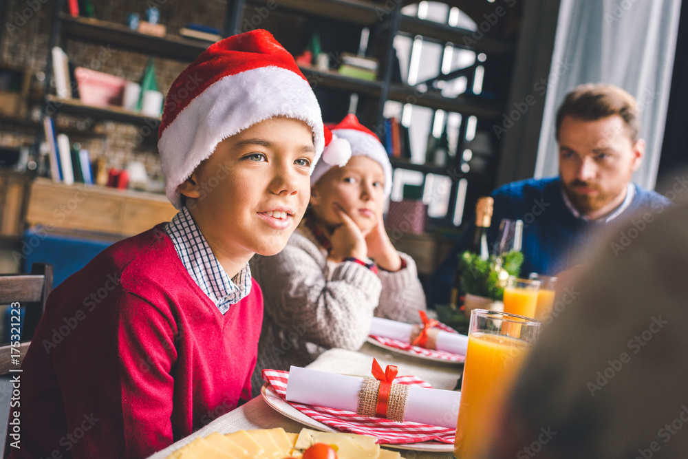 kids sitting at christmas table with father
