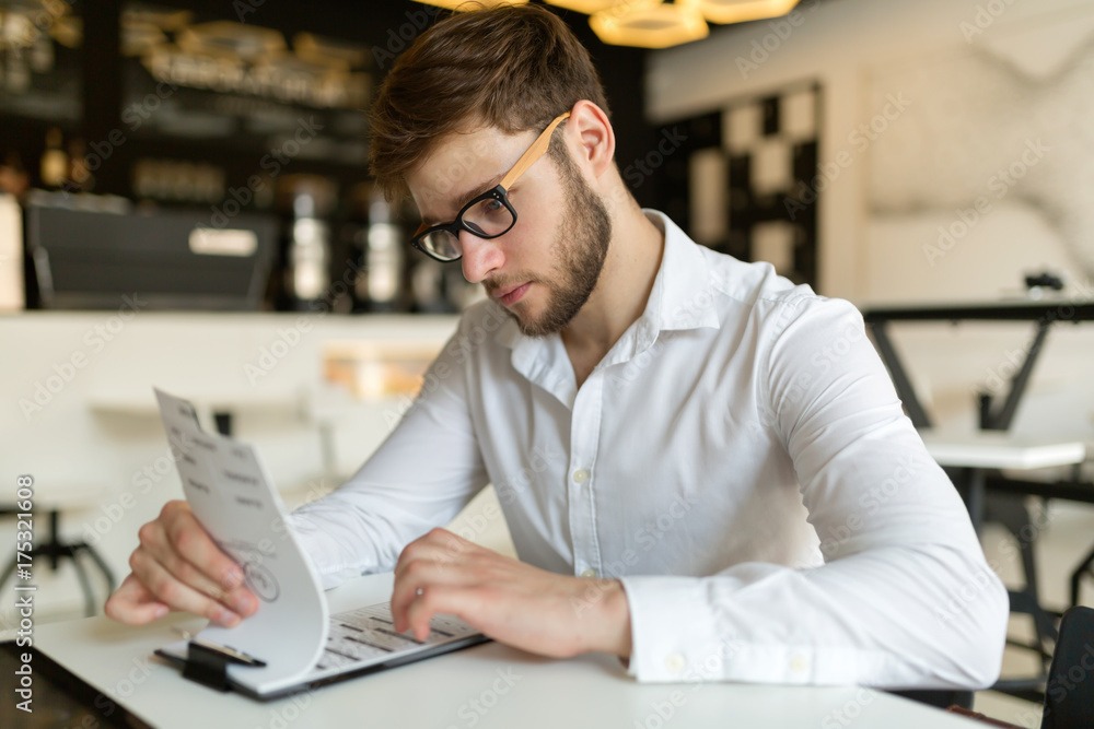 Fototapeta premium Businessman choosing from menu in restaurant