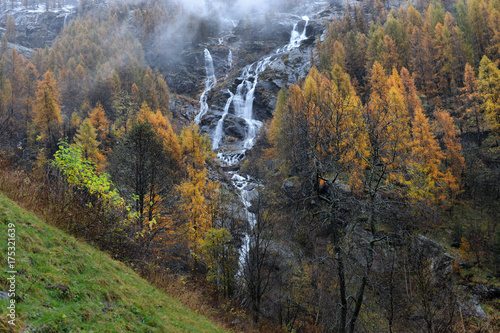 yellow larch and waterfalls in the autumnal Alps