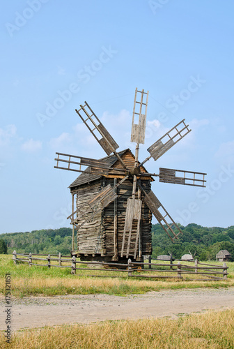 Wooden windmill on the background of the rural landscape
