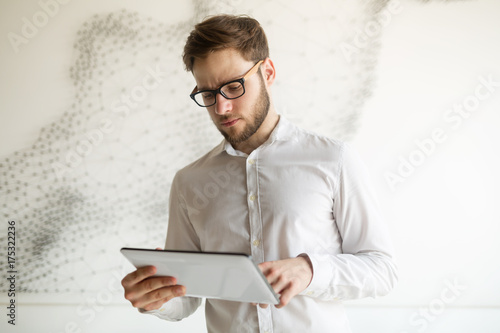 Businessman wearing glasses using tablet