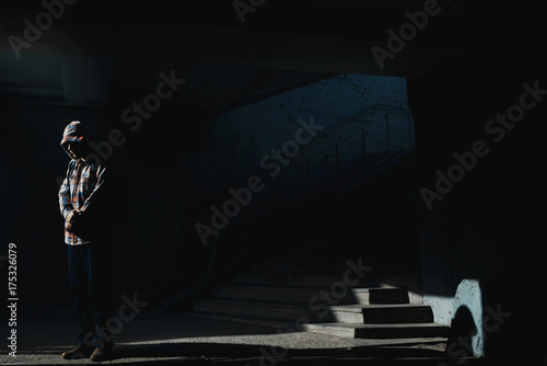 Fotografie Man sits on the ground in darken tunnel