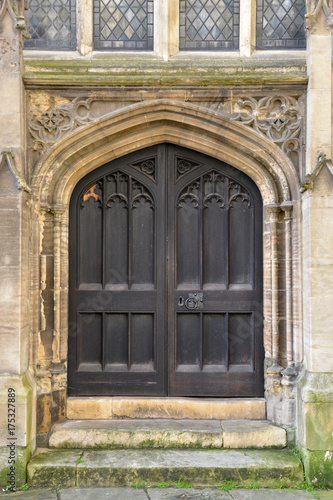 Brown wooden door with a stone wall