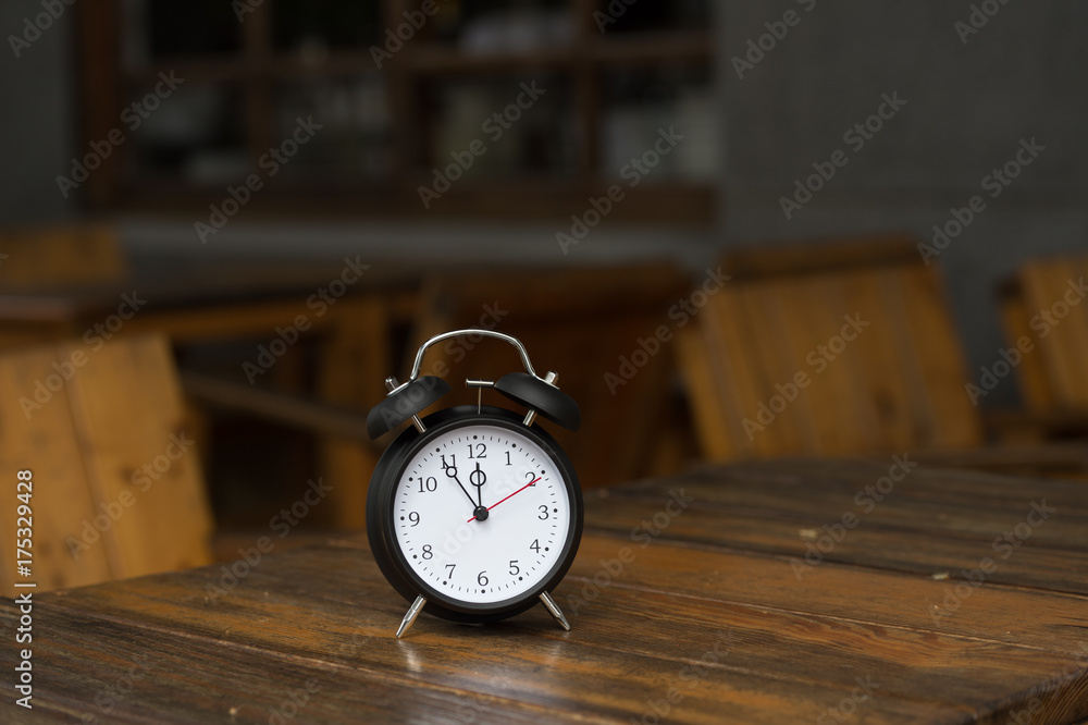 Naklejka premium Retro alarm clock with five minutes to twelve o'clock.