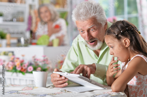 grandfather with granddaughter using laptop