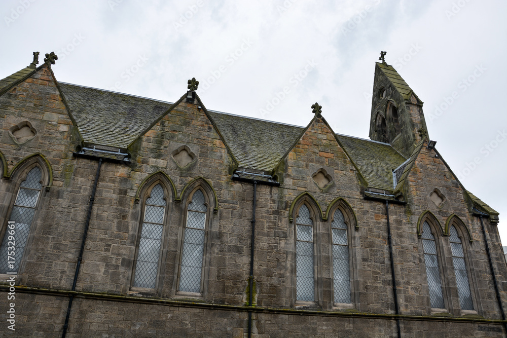 Old medieval Scottish stone church with clouds