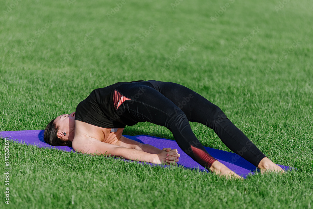 Fototapeta premium young woman doing yoga in the park in the morning in autumn.
