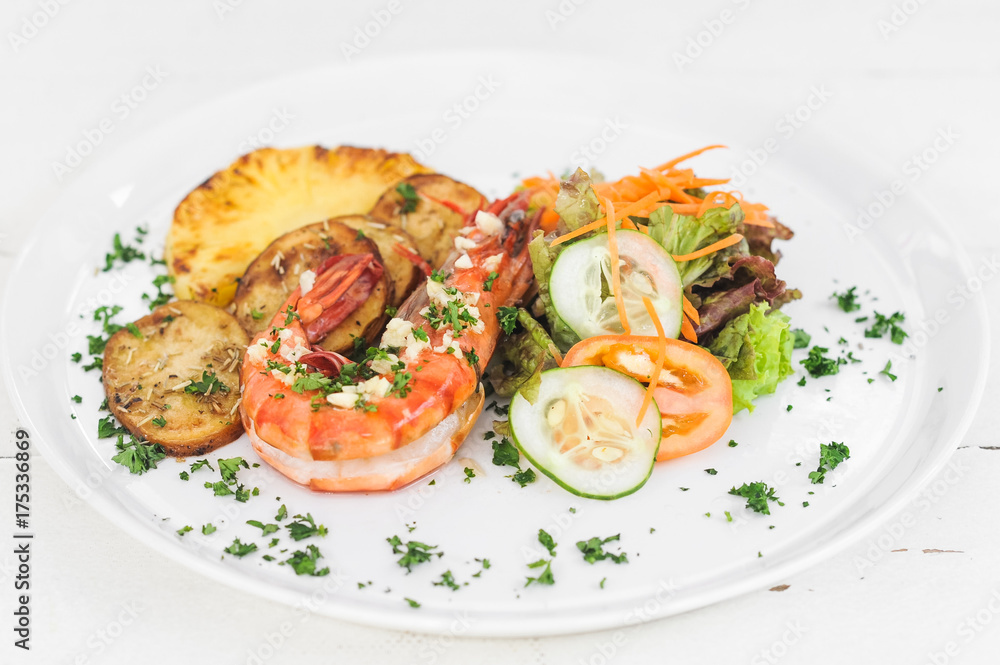 Grilled tiger prawn with potatoes, tomatoes and salad on the white plate Grilled tiger prawn with potatoes, tomatoes and salad on the white plate