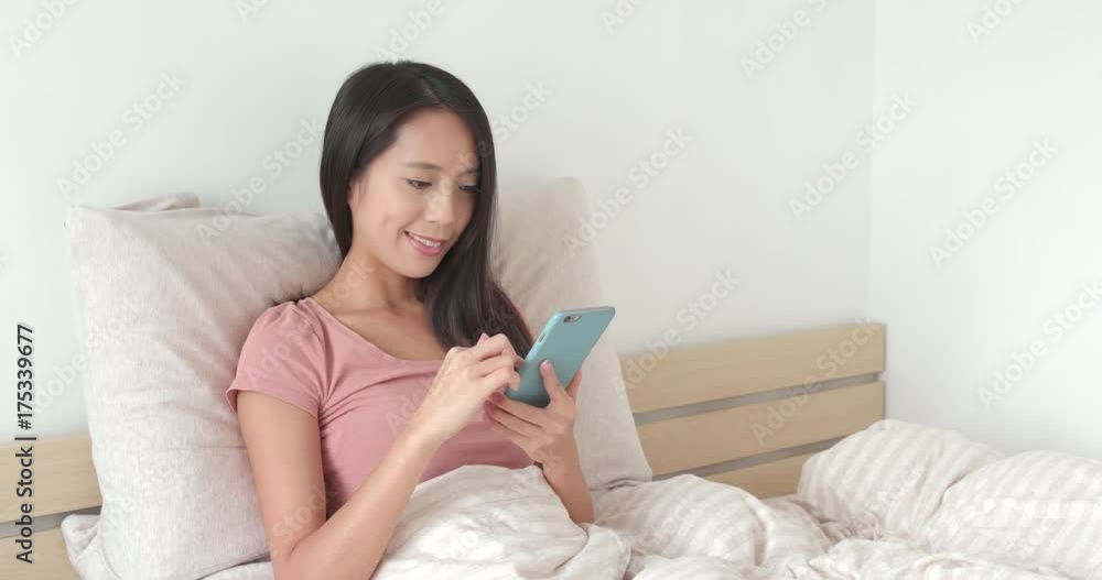 Woman using mobile phone on bed Woman using mobile phone on bed