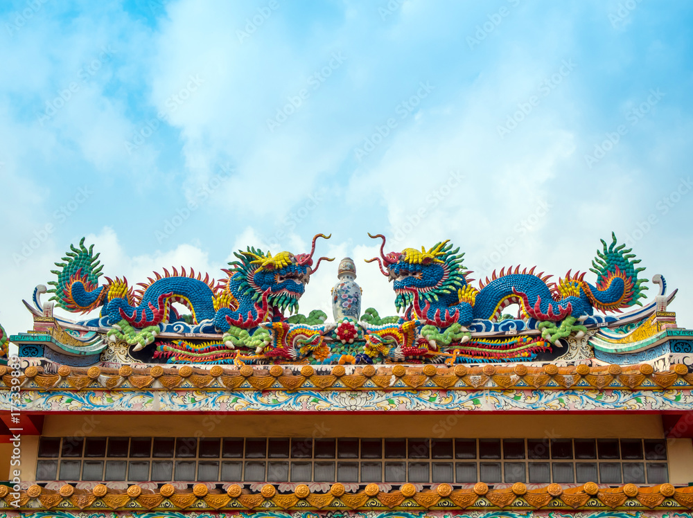 Fototapeta premium Colorful twin chinese dragon sculpture on the roof in chinese temple