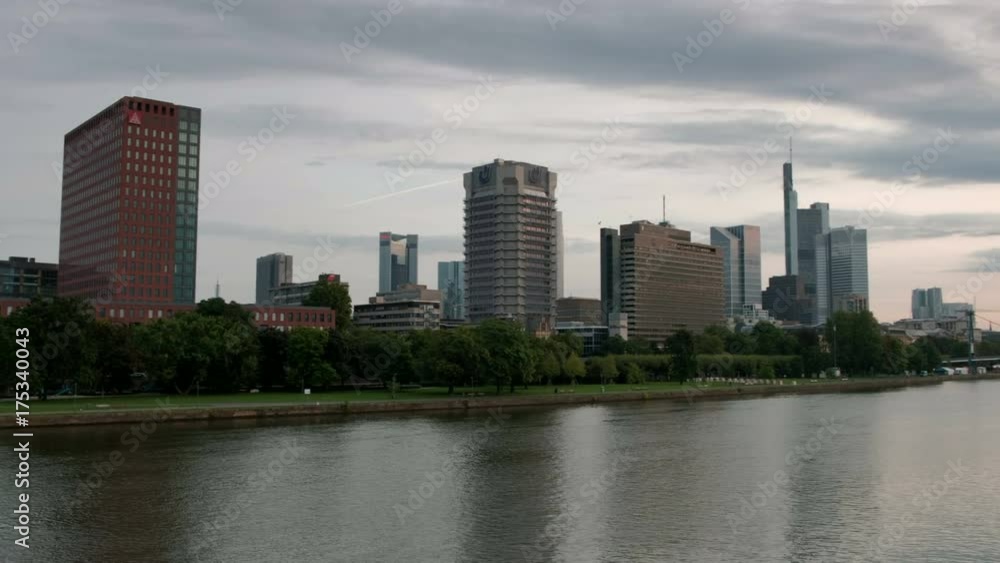 Slow wide pan clip across the River Main and Frankfurt Skyline to the Holbeinsteg Bridge. Taken at dawn on a summers morning Slow wide pan clip across the River Main and Frankfurt Skyline to the Holbeinsteg Bridge. Taken at dawn on a summers morning
