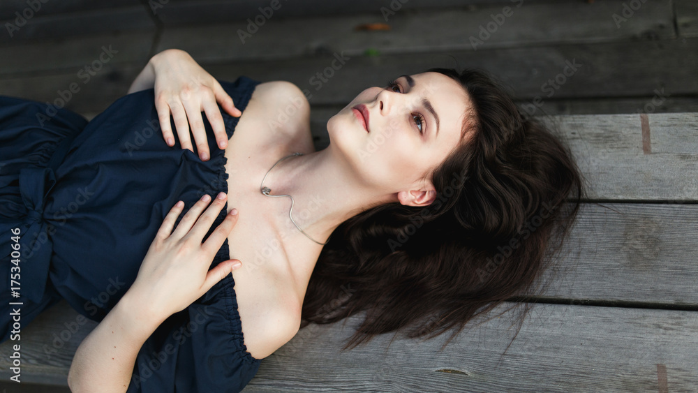 Photo of woman in black dress lying on wooden bench Photo of woman in black dress lying on wooden bench